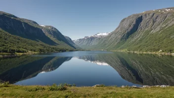 Et majestetisk fjellandskap med en rolig innsjø og en klar himmel.