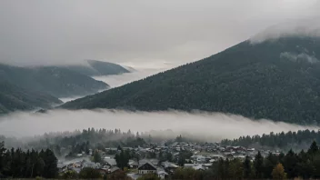 En tett tåke ruller inn over en liten by i fjellet og reduserer sikten til bare noen få meter.