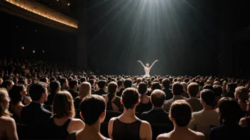 Et ballettpublikum i en teater, med en spotlight på scenen.