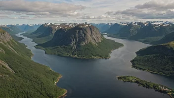 Et luftfoto av et norsk landskap med en blanding av skoger, fjell og vann, med en liten landsby eller by i bakgrunnen.