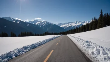 En stor snøtykke som blokkerer en fjellvei, med en klar blå himmel og snødekte fjell i bakgrunnen.