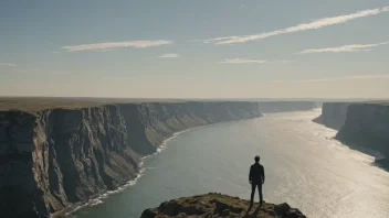 En person som står på kanten av et stup, ser ut på et stort landskap bortom horisonten.