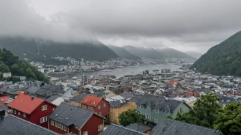 En regnfull og tåkete dag i Bergen, med utsikt over byens ikoniske trehus og et fjellområde i bakgrunnen.