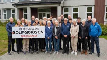 En gruppe mennesker fra ulike aldersgrupper og bakgrunner står sammen foran en boligbygning, med et skilt som leser 'Boligkooperasjon' på norsk.