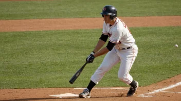 En baseballspiller i aksjon, med en bat i hånden og et bestemt uttrykk i ansiktet.