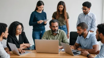 En gruppe mennesker fra ulike bakgrunner og aldre, alle med en felles interesse, samlet rundt et bord med laptoper og notatbøker, engasjert i en diskusjon.