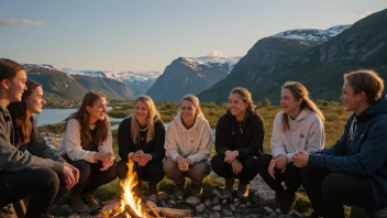 En gruppe elever fra en norsk folkehøyskole, samlet rundt et bål, smiler og chatter, med et naturskjønt norsk landskap i bakgrunnen.