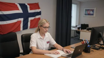 Et bilde av en person som jobber ved et skrivebord med et norsk flagg i bakgrunnen, som representerer en statslønnede.