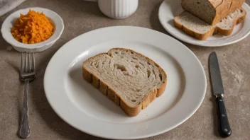 En snei brød på en tallerken med kniv og gaffel