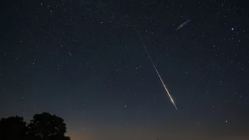 En stjernedryss eller meteorregn i natt himmelen, med klare stjerner og en mørk bakgrunn