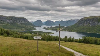 Et idyllisk landskap med rullende åser og fjell i bakgrunnen, med en liten landsby i det fjerne og en skiltstolpe i forgrunnen med navnet Bjørndals skrevet på den.