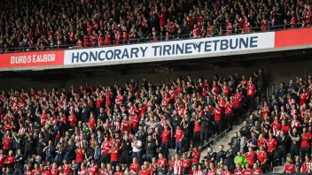 En VIP-seksjon på et stadion med en skilt som sier 'Ærestribune' på norsk, reservert for spesielle gjester