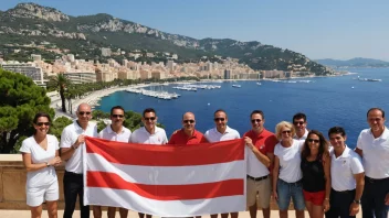 En gruppe mennesker fra Monaco, som står stolte foran Monacos flagg, med en storslagen utsikt over den franske rivieraen i bakgrunnen.