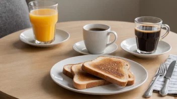 En enkel frokostbordoppsett med en tallerken toast, en kopp kaffe og et glass juice.