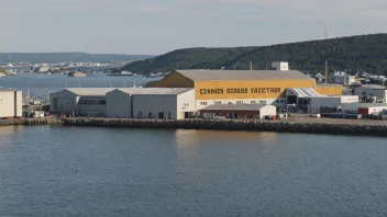 En fabrikkbygning med en skilt som indikerer at det er en konservesfabrikk, beliggende nær en havn med skip i bakgrunnen