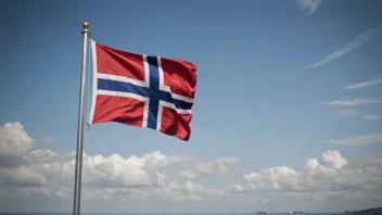 Et flaggstativ med et norsk flagg som vifter i vinden