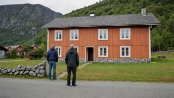 En person som står foran et typisk norsk hus på fastlandet.