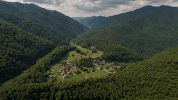 En liten landsby med hus og bygninger omgitt av fjell og skog