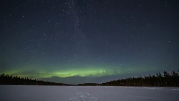 En vakker vinterkveldshimmel med en klar utsikt over stjernene og et subtilt skue av nordlyset