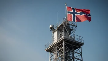 En radiokringkastingsmast med norsk flagg i bakgrunnen.