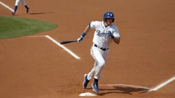 En baseballspiller i aksjon, med en bat i hånden og et bestemt uttrykk i ansiktet.