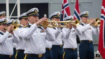 Et militært orkester som spiller på et skip, med et norsk flagg som vifter i bakgrunnen.