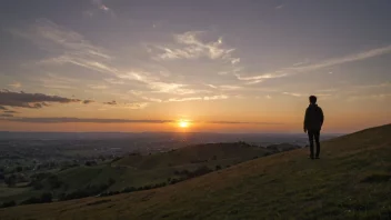 Et fredelig landskap med en person som ser vestover mot en storslått solnedgang.