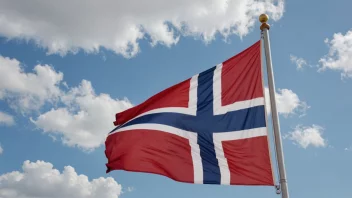 En flaggstøtte med et norsk flagg som vifter i vinden.