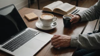 En person som leser en bok med en laptop og en kopp kaffe i nærheten, symboliserer læring og oppdatering av kunnskap