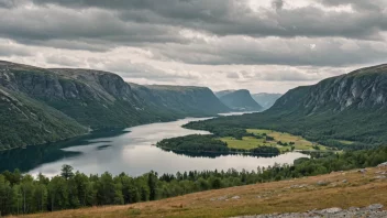 Et fredelig innlandsk landskap i Norge med rullende åser og en innsjø i bakgrunnen.