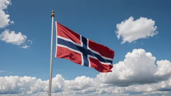 En flaggpæl med et norsk flagg som vifter i vinden.