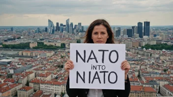 En person som protesterer mot NATO, med en by i bakgrunnen.