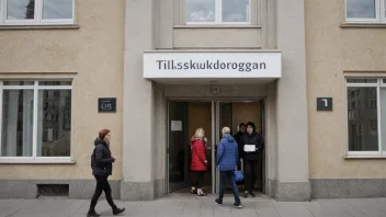 En bygning med en skilt som leser 'Tilskuddsorgan' på norsk, med mennesker som går inn og ut av bygningen.