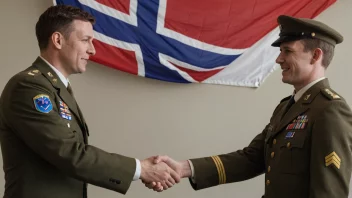 En person i militær uniform som håndhilser med en sivil, med det norske flagget i bakgrunnen.