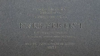 Et bilde av en inskripsjon på et monument, med ordene 'inskribert' og 'gravert' fremhevet.